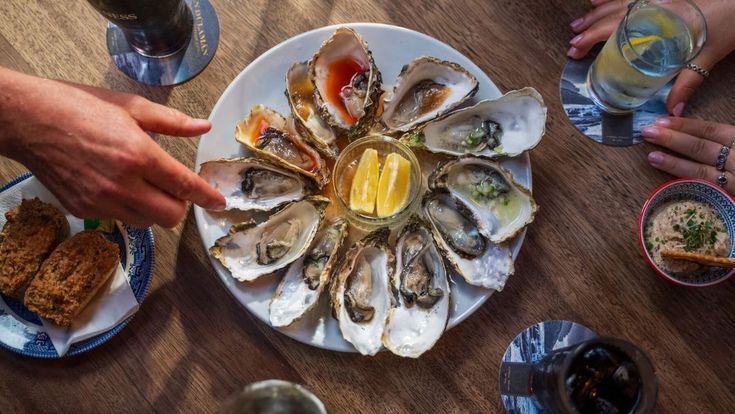 Nahaufnahme eines gedeckten Tisches mit Meeresfrüchten und Wein in einem Restaurant.