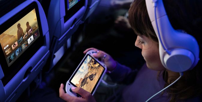 Reisende nutzt mobiles Gerät an Bord mit Starlink Highspeed-WLAN von United Airlines