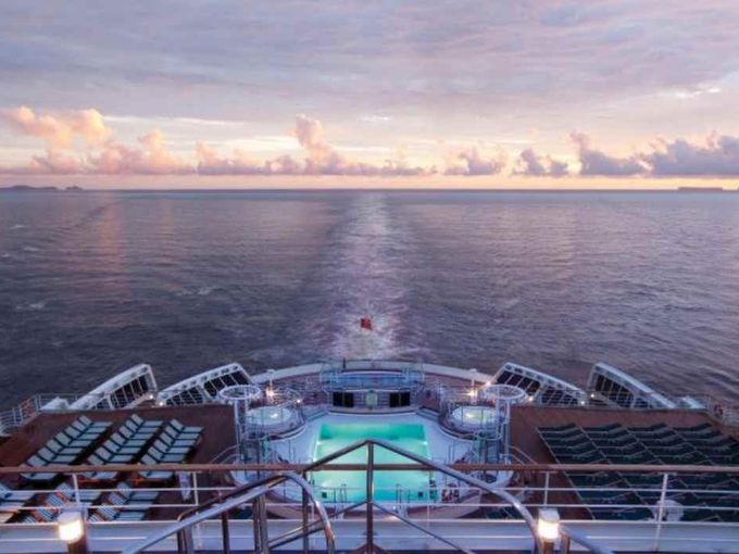 Heckansicht der Queen Mary 2 im Sonnenuntergang