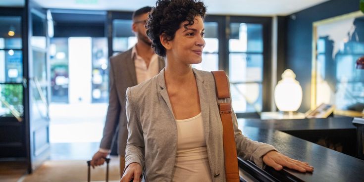 Frau beim Check-in im Hotel © GettyImages