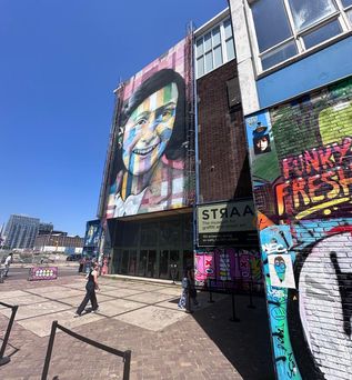 Bunte Streetart-Fassaden beim Straat Museum in Amsterdam bei sonnigem Wetter.