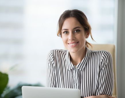 Frau in gestreifter Blus vor Laptop