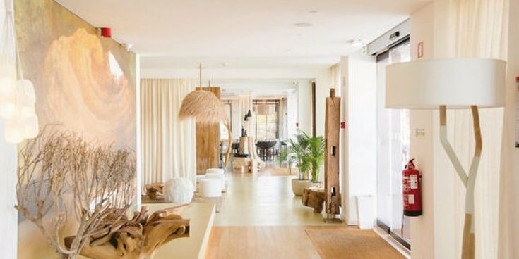 Helles Hotellobby-Interieur mit Naturmaterialien, Holzdekor und sanftem Licht – moderne, ruhige Atmosphäre mit mediterranem Flair.