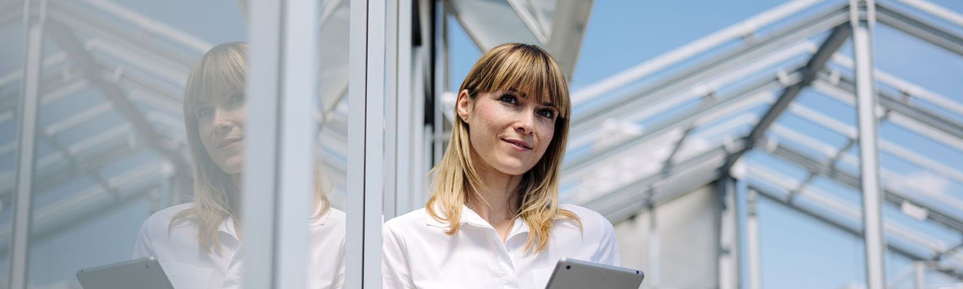 Frau mit Tablet auf Dachterrasse