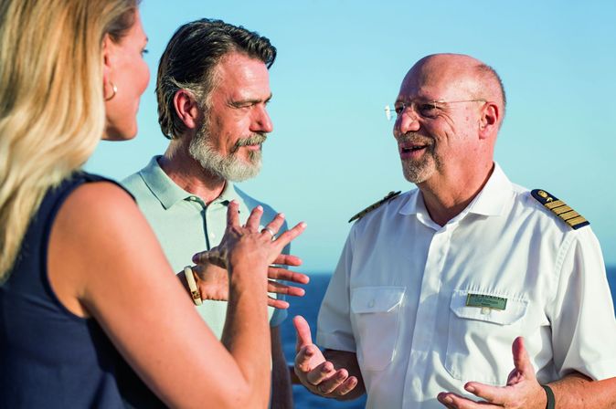 Kapitän auf Schiff spricht mit Gästen