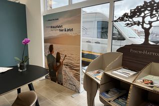 Heller Bürobereich mit Dekoration und Plakatmotiv eines Paares am Meer in der FERNWEHER Reiselounge