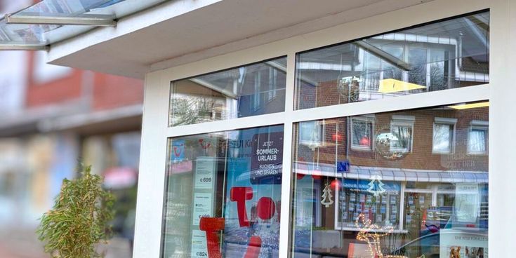 Außenansicht eines Reisebüros mit dem blauen Lufthansa City Center-Schild – Symbol für Reiseberatung und persönliche Betreuung.