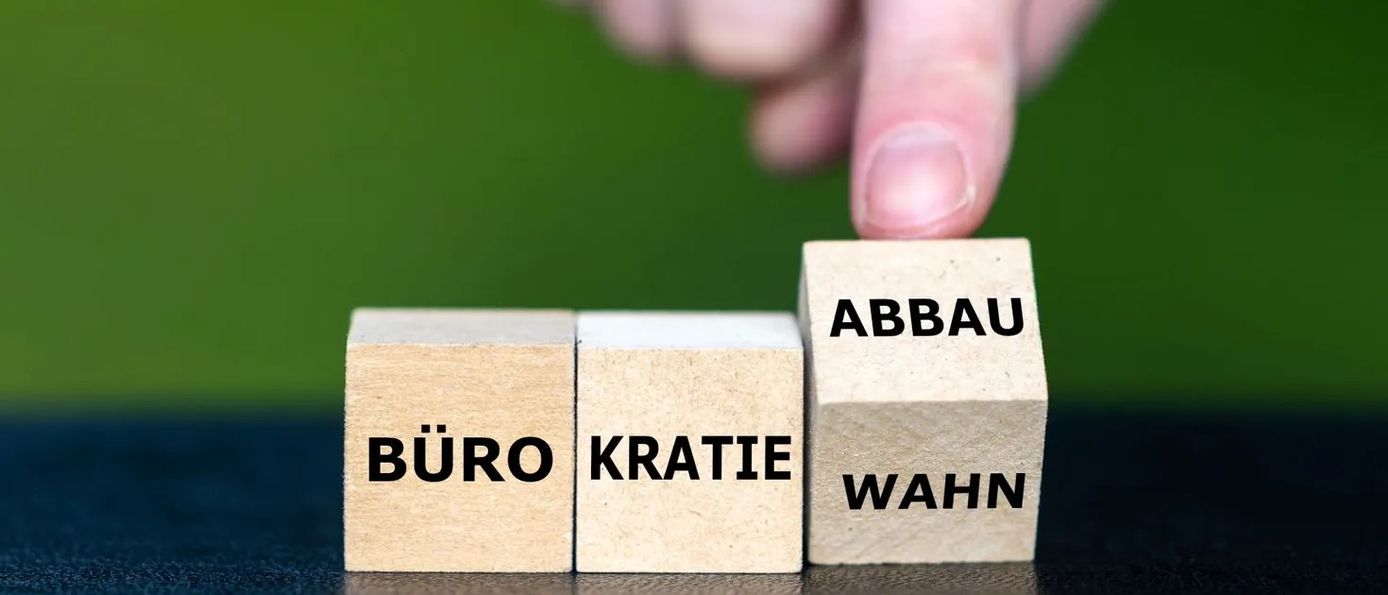 Holzwürfel mit den Worten Bürokratie und Abbau, symbolisch für den Wegfall der A1-Bescheinigungspflicht