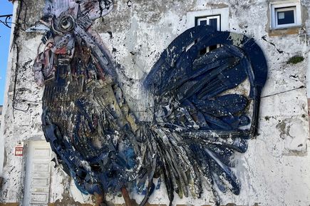 Wandmalerei eines Huhns an einer Hauswand