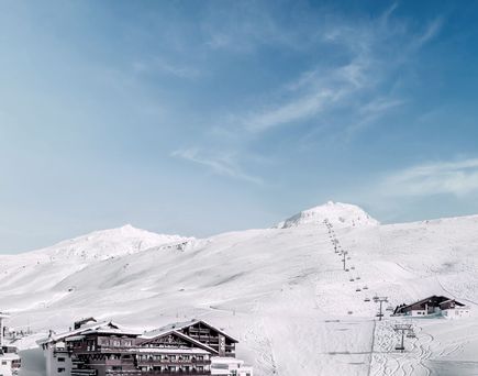 Außenansicht des Top Hotel Hochgurgl inmitten einer verschneiten Berglandschaft.
