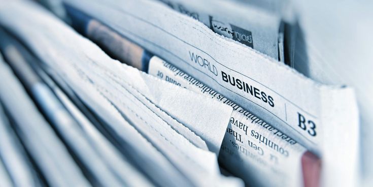 Nahaufnahme eines Stapels von Zeitungen mit sichtbarem Abschnitt der Wirtschaftsseite, auf dem ‚World Business‘ steht.