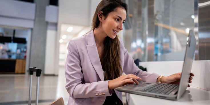 Geschäftsreisende arbeitet mit Laptop im Flughafen