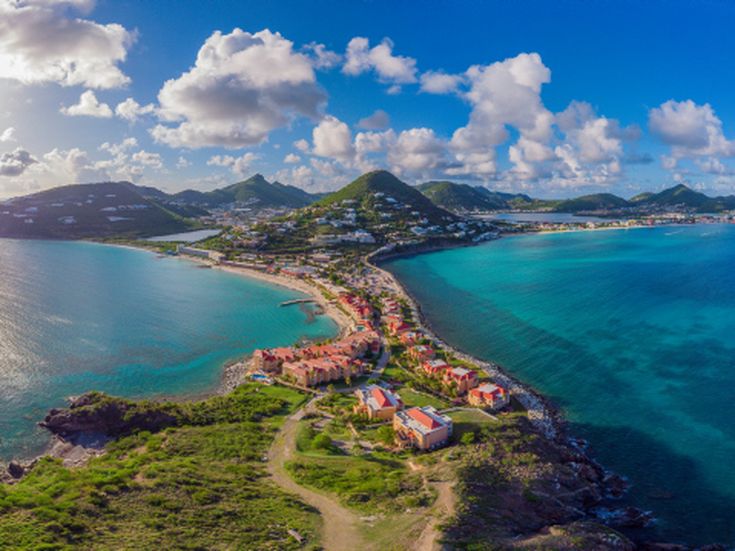 Panoramaaufnahme von Philipsburg mit Bergen in Hintergrund und einer engen Landzunge mit Hotels im Vordergrund