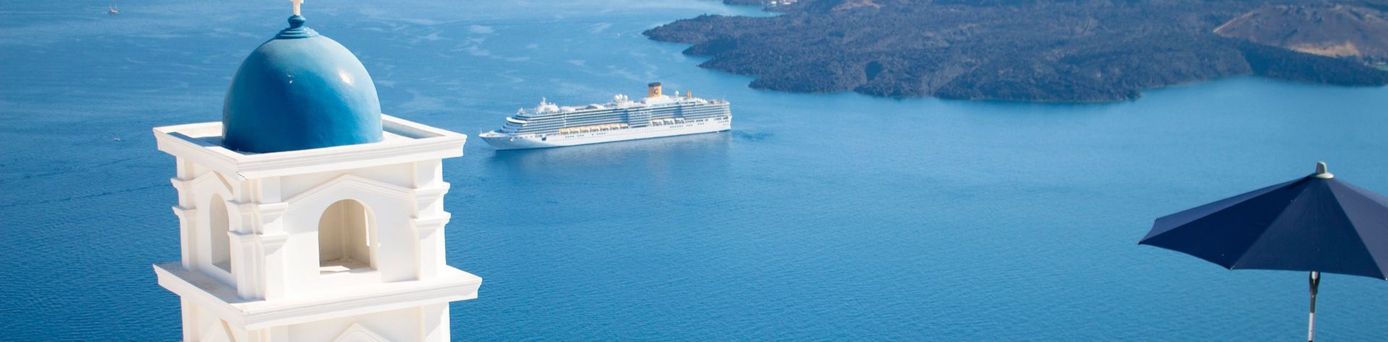 Am Hang stehendes weißes Haus mit blauem Kuppelturm mit Meerblick in Santorin