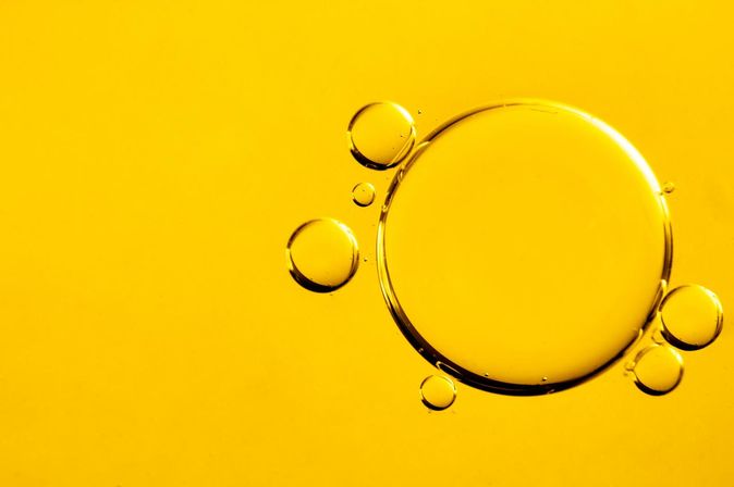 Kleine und große Luftblasen in gelbem Speiseöl