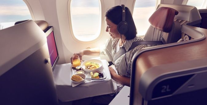 Geschäftsreisende im Flugzeug lächelt © LATAM Airlines