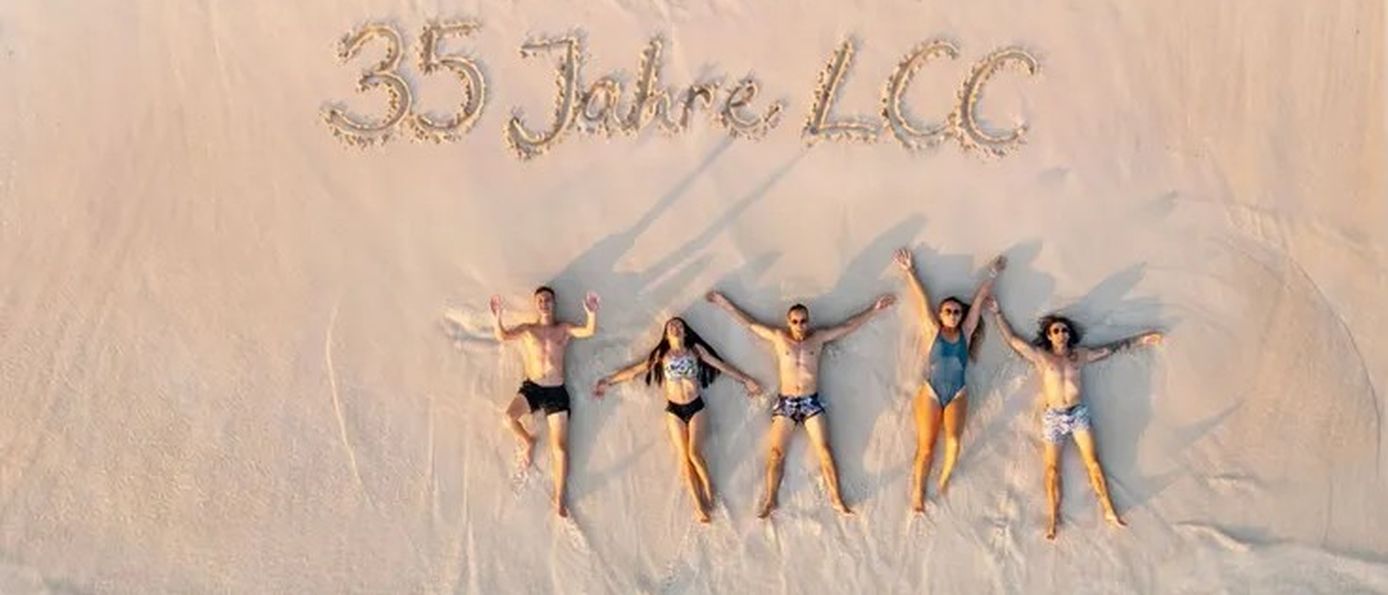 Menschen liegen im Sand mit der Aufschrift "35 Jahre LCC"