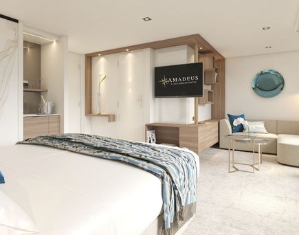 Eine helle und einladende Schiffskabine mit einem komfortablen Bett, eingebauten Schränken, einer kleinen Sitzecke und einem großen Flachbildfernseher.