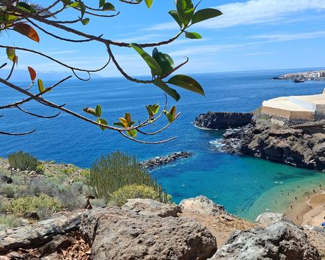 Felsige Bucht mit türkisblauem Wasser und kleinem Sandstrand an der Küste Teneriffas.