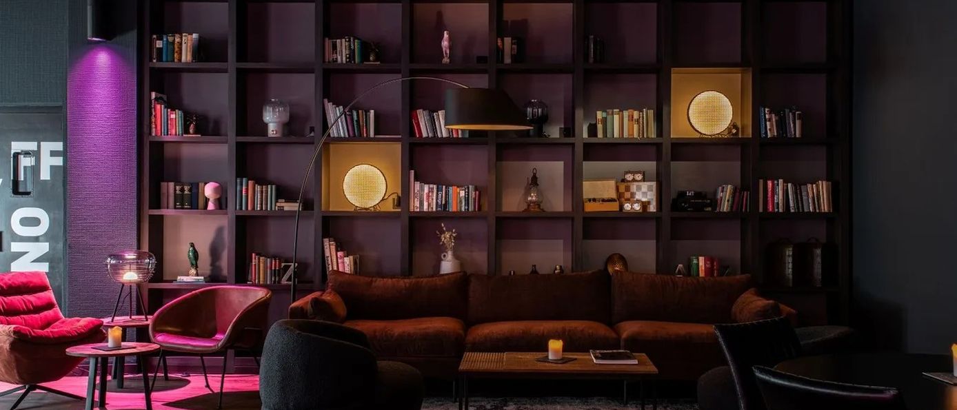 Gemütliche Pentalounge im Penta Hotel mit warmer Beleuchtung, Sofas und Bücherregalen, ideal zum Entspannen nach einem langen Arbeitstag