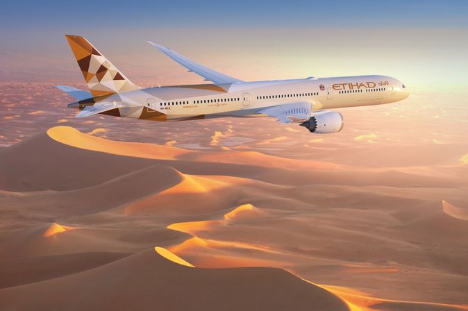 Boeing 787 von Etihad Airways in der Luft über einer Wüstenlandschaft