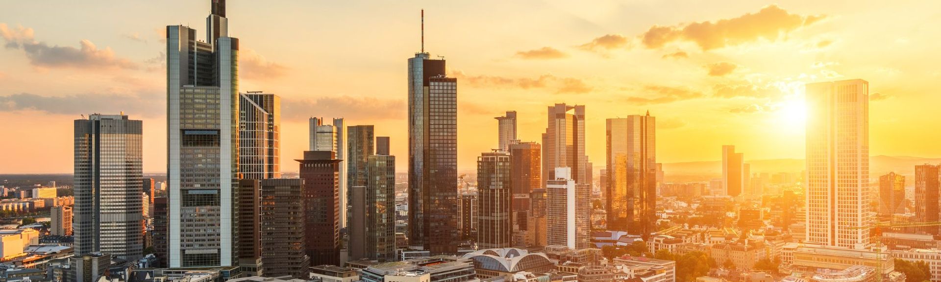 Blick auf die Skyline von Frankfurt am Main bei Sonnenuntergang mit modernen Hochhäusern und warmem Abendlicht – Symbol für Wirtschaft, Business und Urbanität.