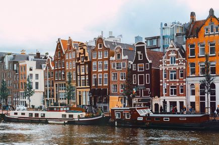 Häuserfassaden, Boote und Fluss in Amsterdam
