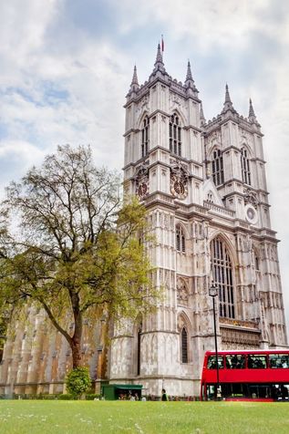 Westminster Abbey in London mit rotem Doppeldeckerbus im Vordergrund