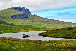 Grüne hügelige Landschaft mit Fluss in Schottland