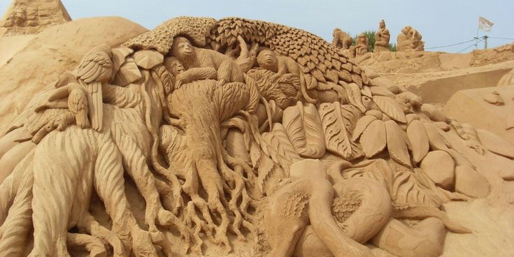 Detailreiche Sandskulptur mit Tieren und Figuren, kunstvoll aus Sand geformt.