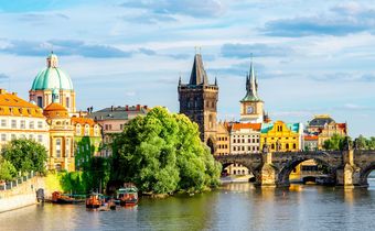 Blick auf die Karlsbrücke und die Altstadt von Prag mit historischen Türmen und bunten Häusern am Ufer der Moldau.