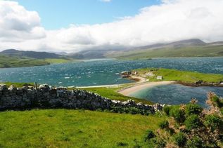 Grüne hügelige Landschaft am See in Schottland