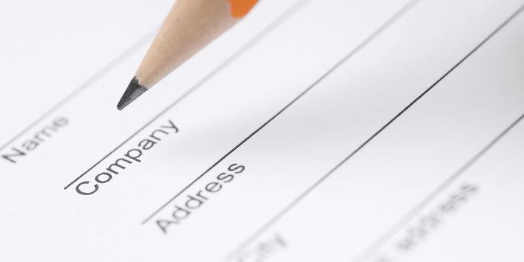 Nahaufnahme eines Formulars mit einem Bleistift, der auf das Feld ‚Company‘ zeigt – Symbolbild für Anmeldung oder Registrierung.