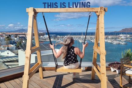 Hannah auf einer Holzschaukel mit Blick auf den Hafen