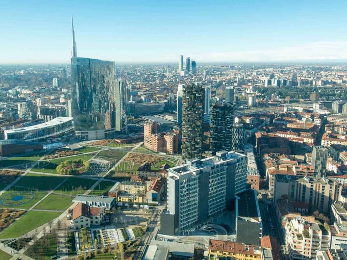 Luftaufnahme von Mailand mit Hochhäusern, Park und Stadtpanorama bei klarem Himmel.