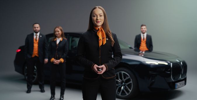 Stationsmitarbeiter von SIXT vor einer BMW Limousine