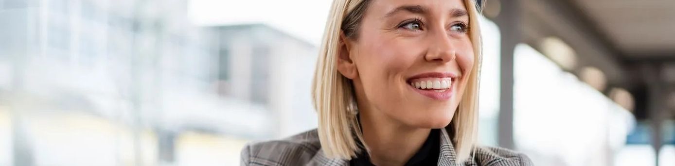 Geschäftsreisende im Meeting mit Laptop und Reiserichtlinien-Dokument auf dem Tisch