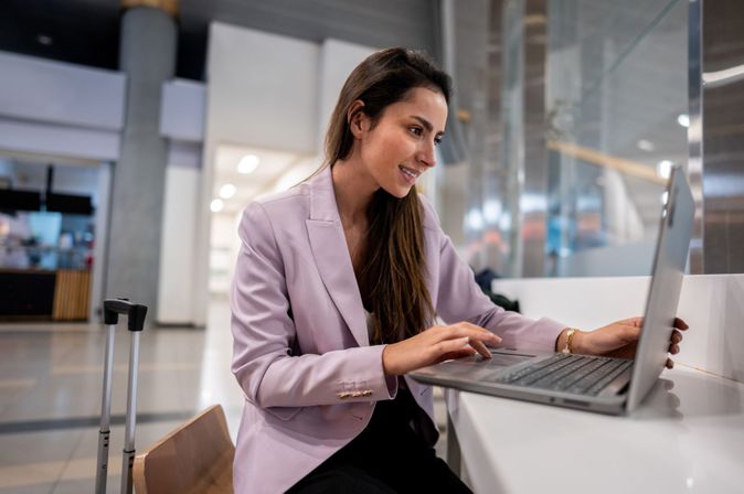 Geschäftsreisende arbeitet mit Laptop im Flughafen