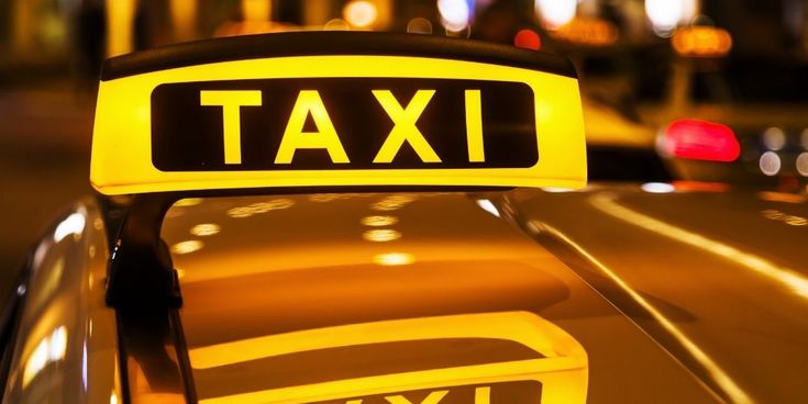 Gelbes Taxi mit leuchtendem Taxi-Schild
