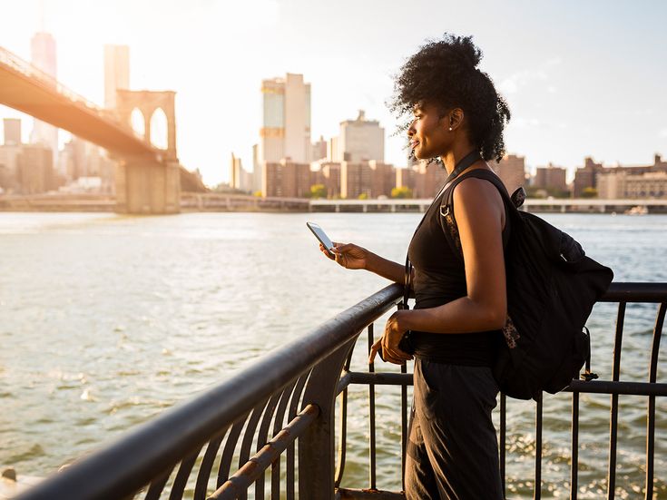 Frau mit Handy bei Brooklyn Bridge