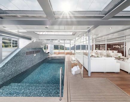 Eine helle und einladende Schiffskabine mit einem komfortablen Bett, eingebauten Schränken, einer kleinen Sitzecke und einem großen Flachbildfernseher.