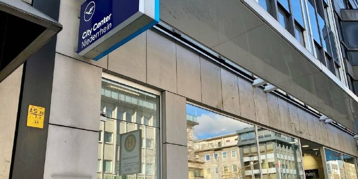 Außenansicht eines Reisebüros mit dem blauen Lufthansa City Center-Schild – Symbol für Reiseberatung und persönliche Betreuung.