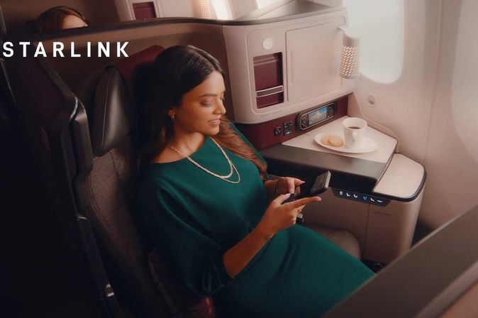 Frau nutzt Starlink in der Qsuite an Bord von Qatar Airways