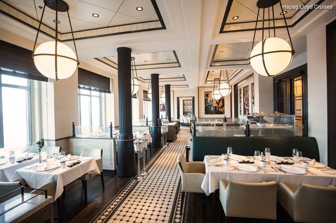 Gedeckte Tische im Restaurant vom Schiff MS Europa 2 der Reederei Hapag Lloyd Cruises