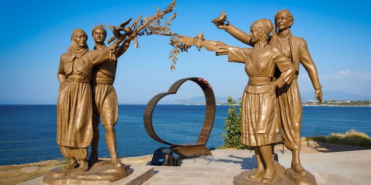 Friedensdenkmal mit vier bronzenen Figuren und Herzskulptur am Meer in Didim an der türkischen Ägäisküste.