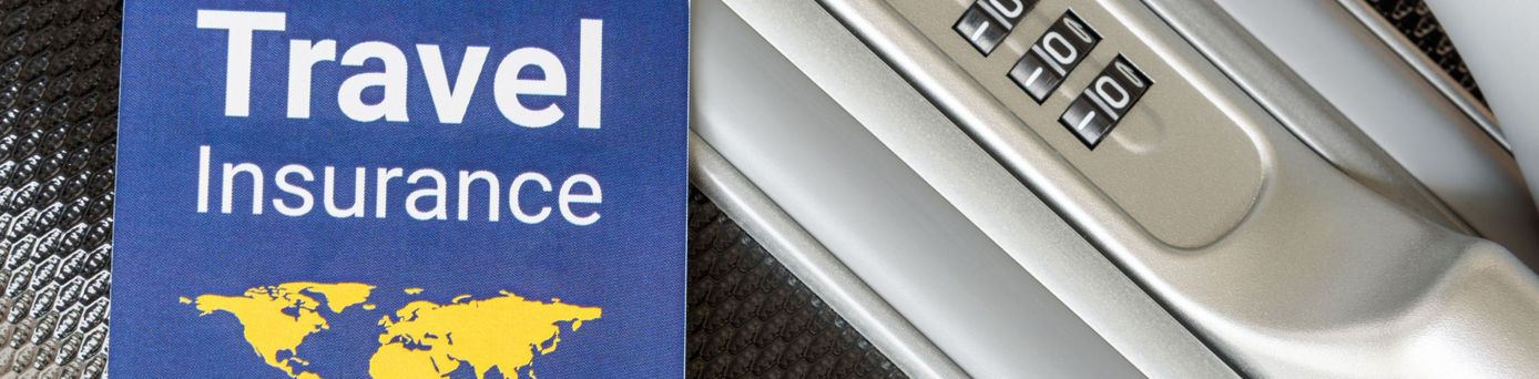 Koffergriff mit angehängtem Etikett mit der Aufschrift ‚Travel Insurance – International‘ – Symbol für Sicherheit und Schutz auf Reisen.