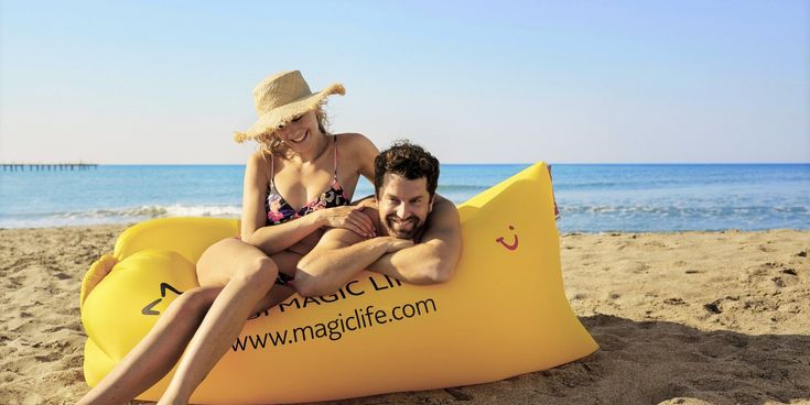 Ein Paar entspannt am Strand auf einem gelben TUI MAGIC LIFE Luftsofa vor dem Meer – Sinnbild für Lebensfreude, Zweisamkeit und All-Inclusive-Urlaub am Meer.