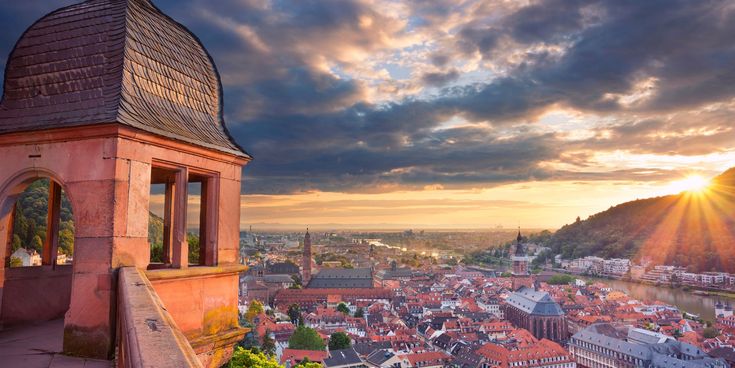 Blick vom Heidelberger Schloss über die Altstadt mit der Heiliggeistkirche und dem Neckar bei Sonnenuntergang.