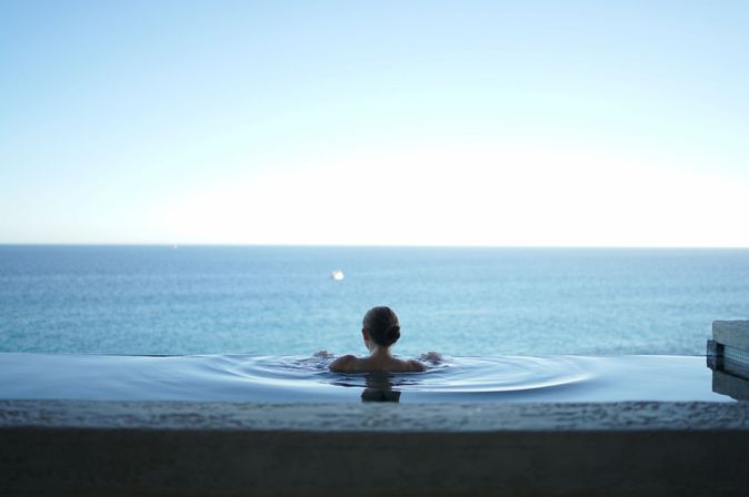 Frau entspannt im Infinity Pool einer Malediven Insel